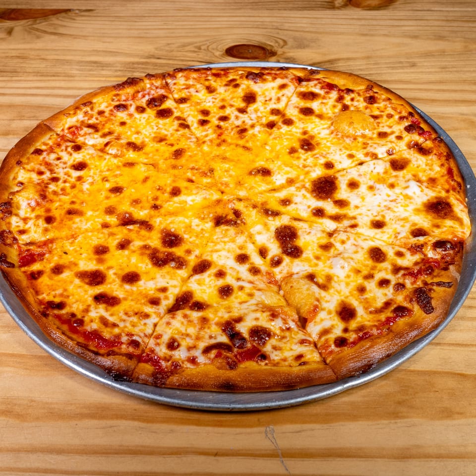 Large rectangular cheese pizza with a golden-brown crust, cut into squares and served on a metal tray atop a wooden table.